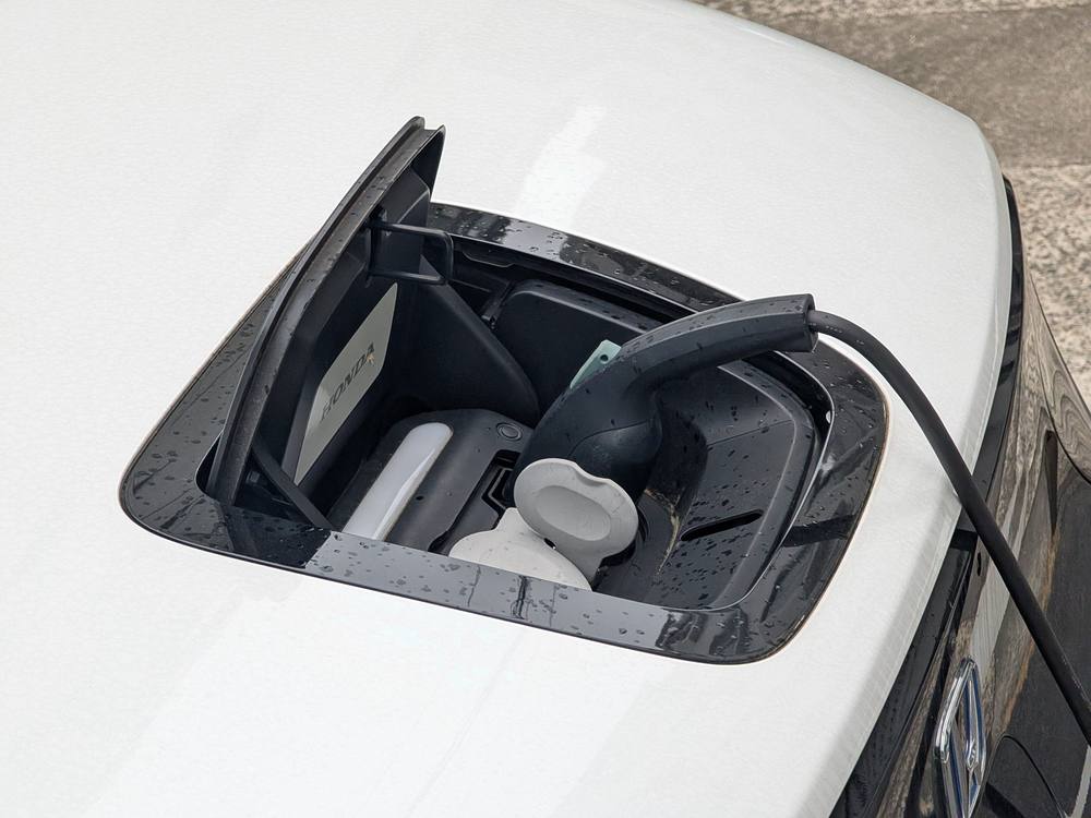 Cable de recarga conectado a la toma de un vehículo eléctrico