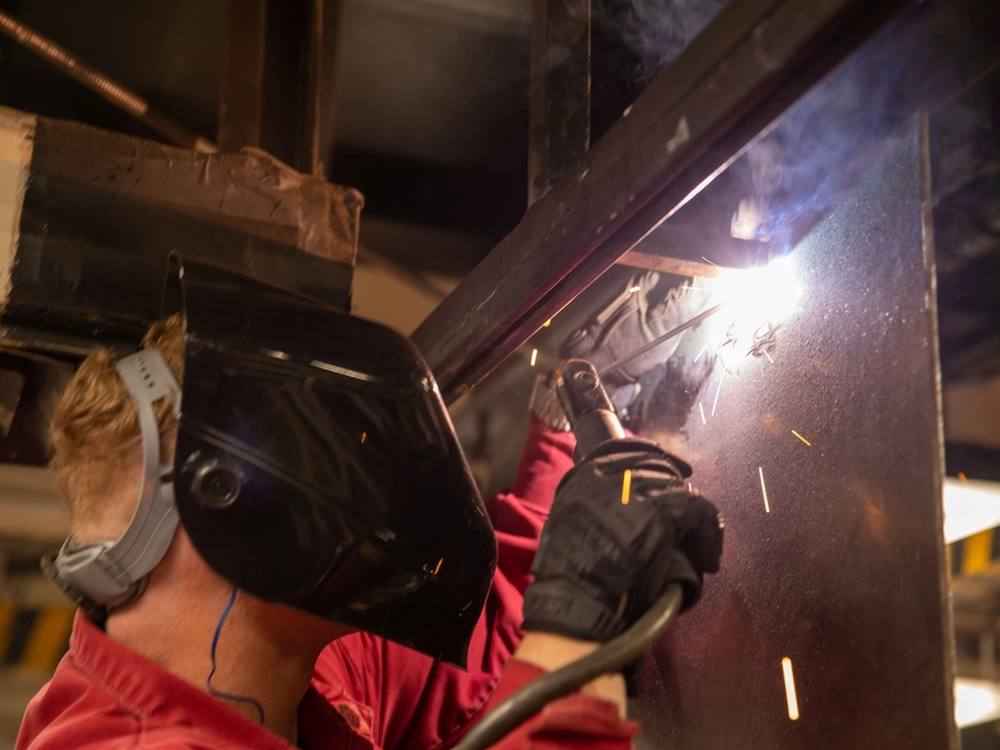 Soldador trabajando sobre una estructura metálica en el taller