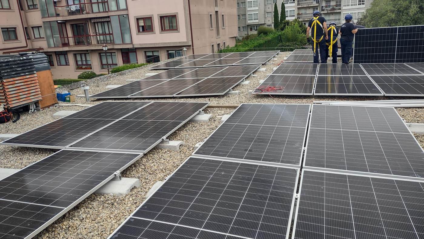 Paneles solares instalados sobre la cubierta plana de un edificio de viviendas